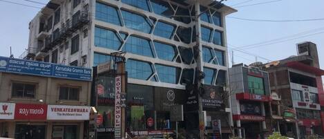 Un hotel de varios pisos con un diseño arquitectónico moderno, que cuenta con ventanas y balcones amplios.