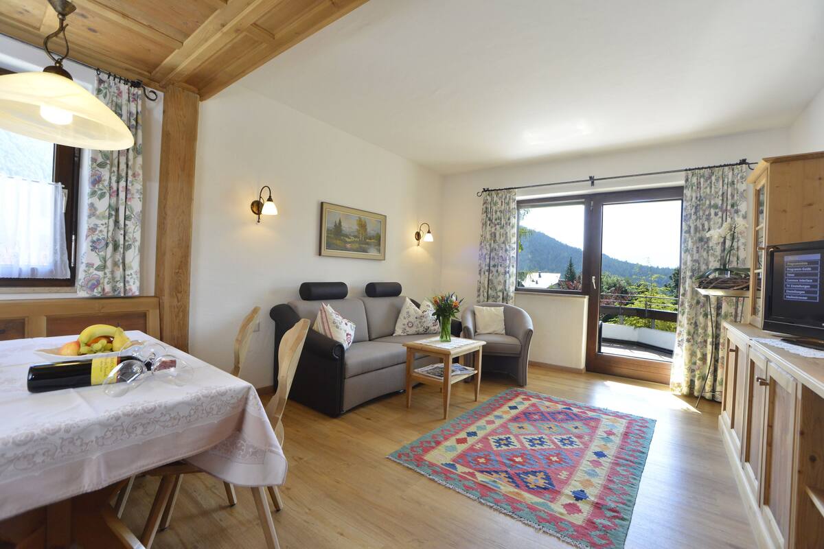 A cozy living room with a sofa, a coffee table, and a dining area with a table set for two.