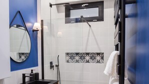 A modern bathroom with a shower, a sink with a mirror, and a towel rack. - Le Cafe des Invalides - Eiffel Tower (Paris)