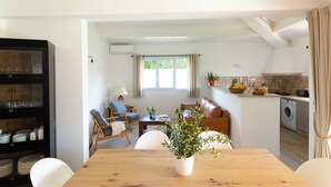 A modern kitchen with a dining area, a built-in cabinet, and a view of a person in the background. - GARDEN VILLA 3 MINUTES WALK FROM CALA ROSSA BEACH - RESIDENCE MARINA ROSSA (Lecci)