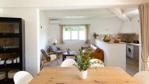A modern kitchen with a dining area, a built-in cabinet, and a view of a person in the background. - GARDEN VILLA 3 MINUTES WALK FROM CALA ROSSA BEACH - RESIDENCE MARINA ROSSA (Lecci)