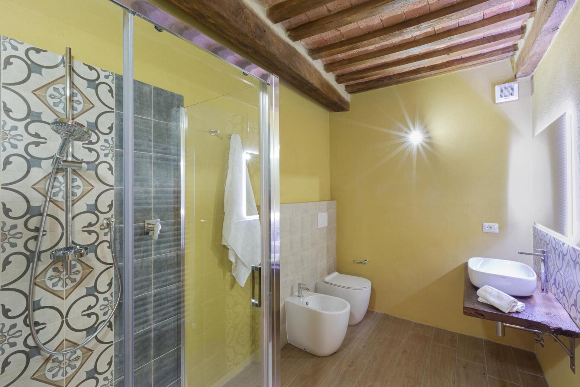 A bathroom with a shower, toilet, and sink.