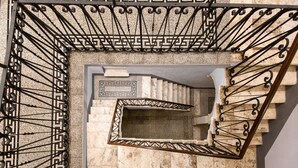 A spiral staircase with a geometric pattern on the walls and a metal railing. - B&B Gli Archi (Abbadia San Salvatore)
