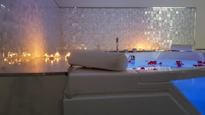 A spa area with a bathtub, candles, and rose petals. - Finca El Pastel (Tacoronte)