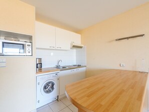A compact kitchen with a microwave, coffee maker, sink, and washing machine. - Seaside studio for 2 in Châtelaillon-Plage with parking (Châtelaillon-Plage)