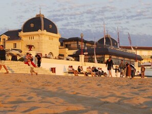 A beachside building with a dome and a large window, surrounded by sand and people. - Seaside studio for 2 in Châtelaillon-Plage with parking (Châtelaillon-Plage)