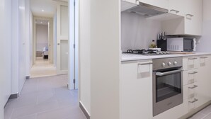Eine moderne Küche mit weißen Schränken, einer Mikrowelle, einem Herd und einem Backofen.