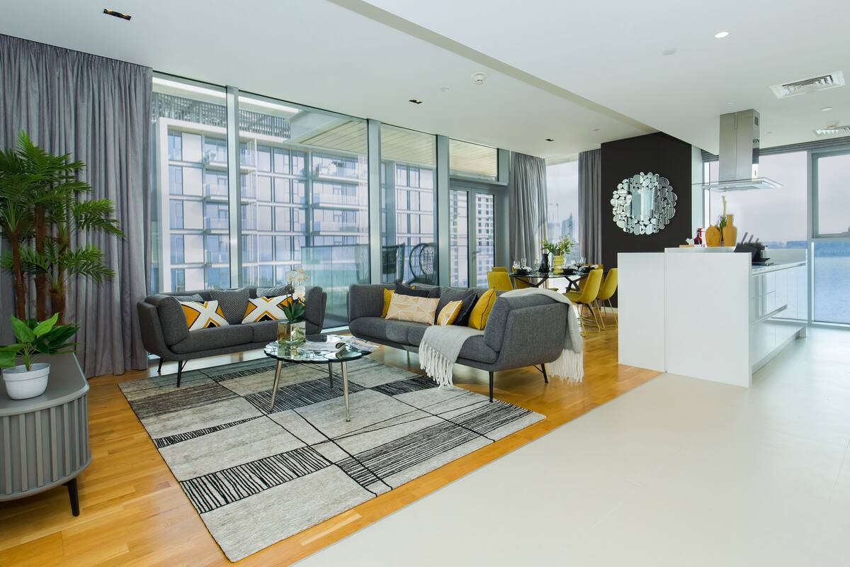 A modern living room with a sofa, coffee table, and a dining area with chairs.