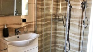 Luxe vierpersoonskamer | Badkamer | Een bad/douchecombinatie, een bubbelbad, een hydromassagedouche