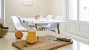 A kitchen counter with a cutting board, a knife, an orange, and a glass of orange juice. - Bravissimo Cort Reial 3B, fantastic apartment (Girona)