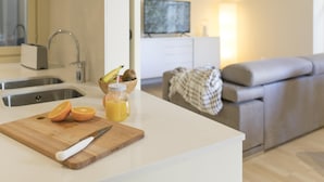 A modern kitchen with a cutting board, knife, and a fruit bowl with sliced oranges. - Bravissimo Cort Reial 3B, fantastic apartment (Girona)