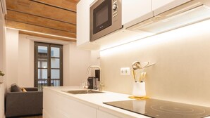 A modern kitchen with a built-in microwave, a stainless steel sink, and a black induction cooktop.