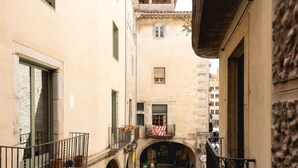 Una calle estrecha con edificios de piedra, un pequeño patio y un letrero de restaurante.