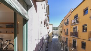 A narrow street with buildings on either side, a bicycle parked outside a building, and a clear sky. - Bravissimo Sunset, comfort in the Old Town (Girona)