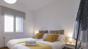 A bedroom with a large bed, two bedside tables, a window, and a lamp. - Bravissimo Sunset, comfort in the Old Town (Girona)