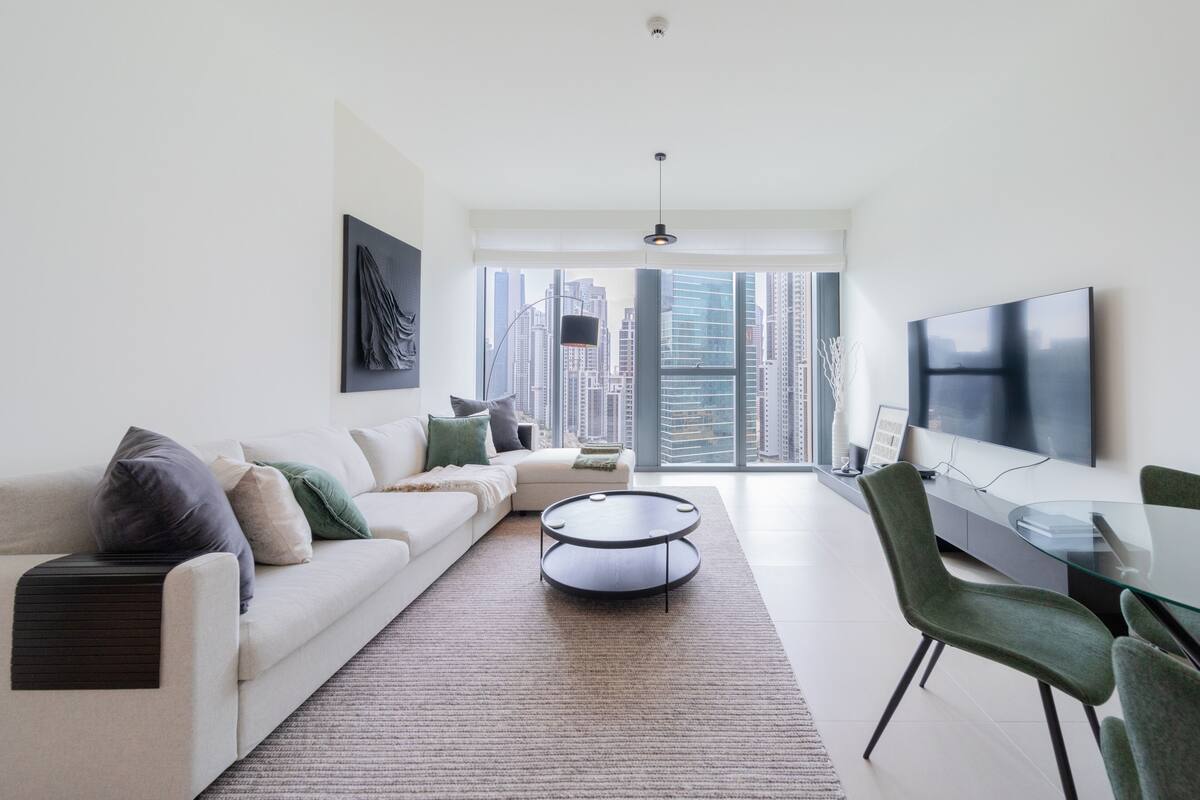 A modern living room with a sofa, a coffee table, and a TV.