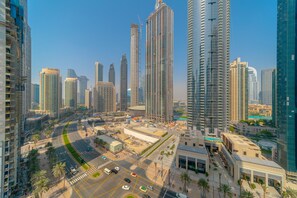 A high-rise urban area with modern skyscrapers, a wide road, and palm trees. - EDEN'S Homes & Villas - BLVD Heights (Dubai)