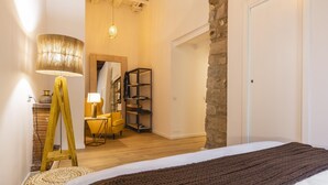 A bedroom with a bed, a lamp, a chair, a shelf, and a wooden ladder. - Bravissimo Bali, beautiful 2-bedroom apartment (Girona)