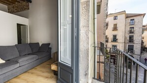 A balcony with a grey sofa and a wooden floor. - Bravissimo Bali, beautiful 2-bedroom apartment (Girona)