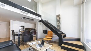 Un appartement moderne doté d’une cuisine, d’un coin repas et d’un escalier.