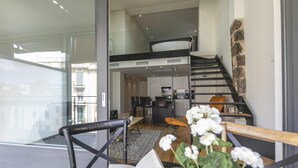 Un appartement moderne comprenant un coin repas, une cuisine et un escalier.