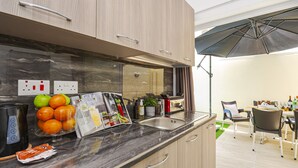 Eine moderne Küche mit Marmorarbeitsplatte, integriertem Backofen und einem Essbereich mit Tisch und Stühlen.