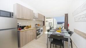 Een moderne keuken met een eethoek, een wasmachine en uitzicht op de stad.