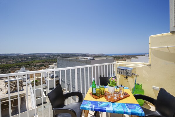 Een balkon met een tafel voor twee, met uitzicht op een prachtig landschap.