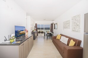 Departamento, 3 habitaciones | Área de sala de estar | Televisión LED de 40 pulgadas con canales vía satélite y televisión 
