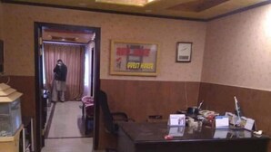 Um saguão de hotel com um balcão de recepção, um aquário e uma placa indicando uma residência para hóspedes.