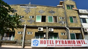 Um edifício com uma placa indicando 'Hotel Pyramid Intl.' e informações de contato.