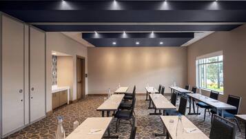A conference room with long tables, chairs, and water bottles.