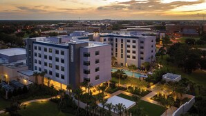 A modern hotel complex with multiple buildings, a swimming pool, and landscaped gardens. - The Celeste Hotel, Orlando, a Tribute Portfolio Hotel (Orlando)