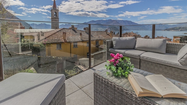 A terrace with wicker furniture, a glass table, and a book. - La Terrazza di Marta (Varenna)