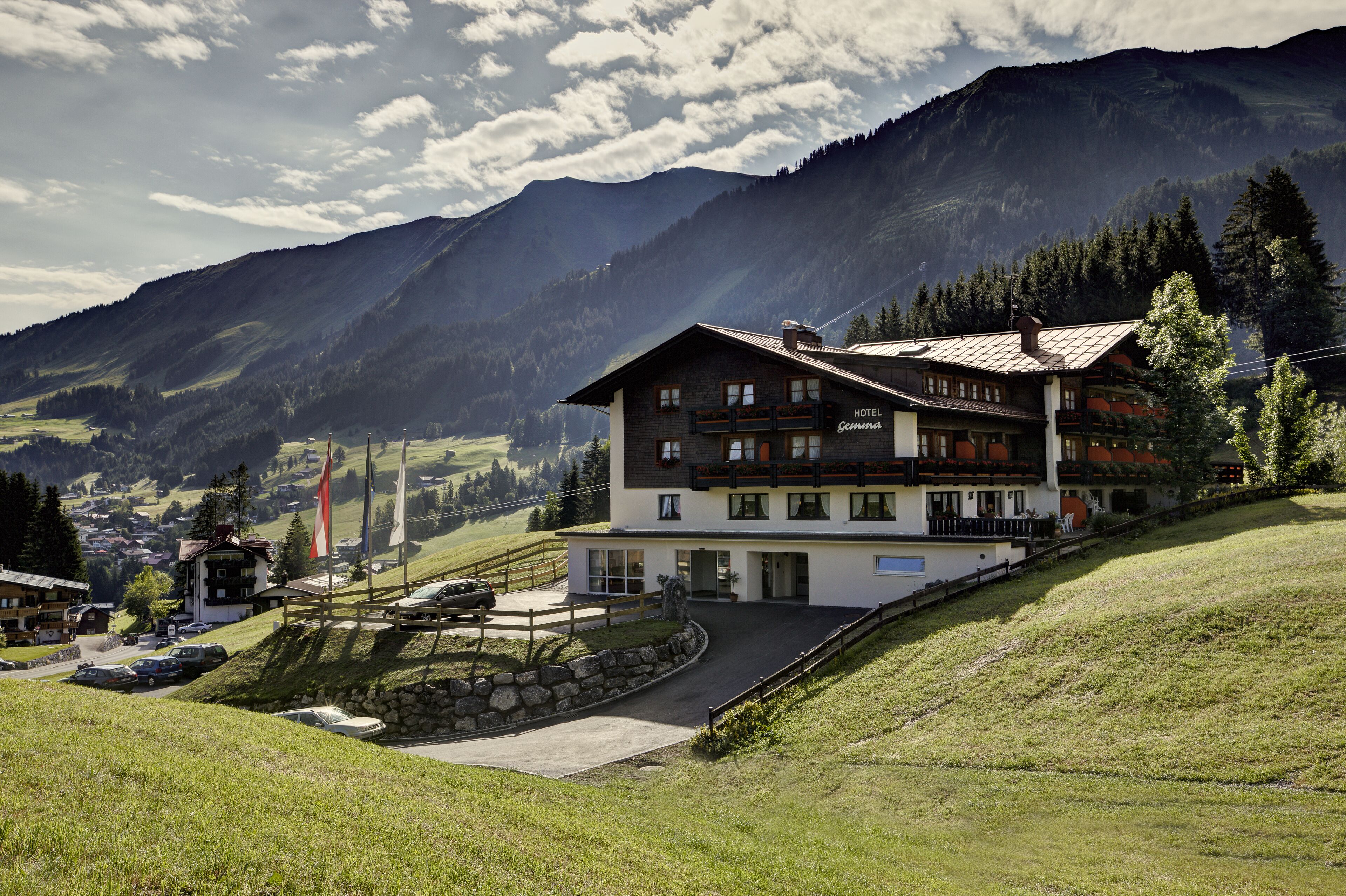 Un hôtel de style alpin traditionnel, doté d’un balcon imposant et offrant une vue sur les montagnes environnantes.