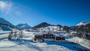 A snow-covered mountain town with buildings, including a hotel with a sign reading "Hotel Gemma". - Hotel Gemma (Mittelberg)