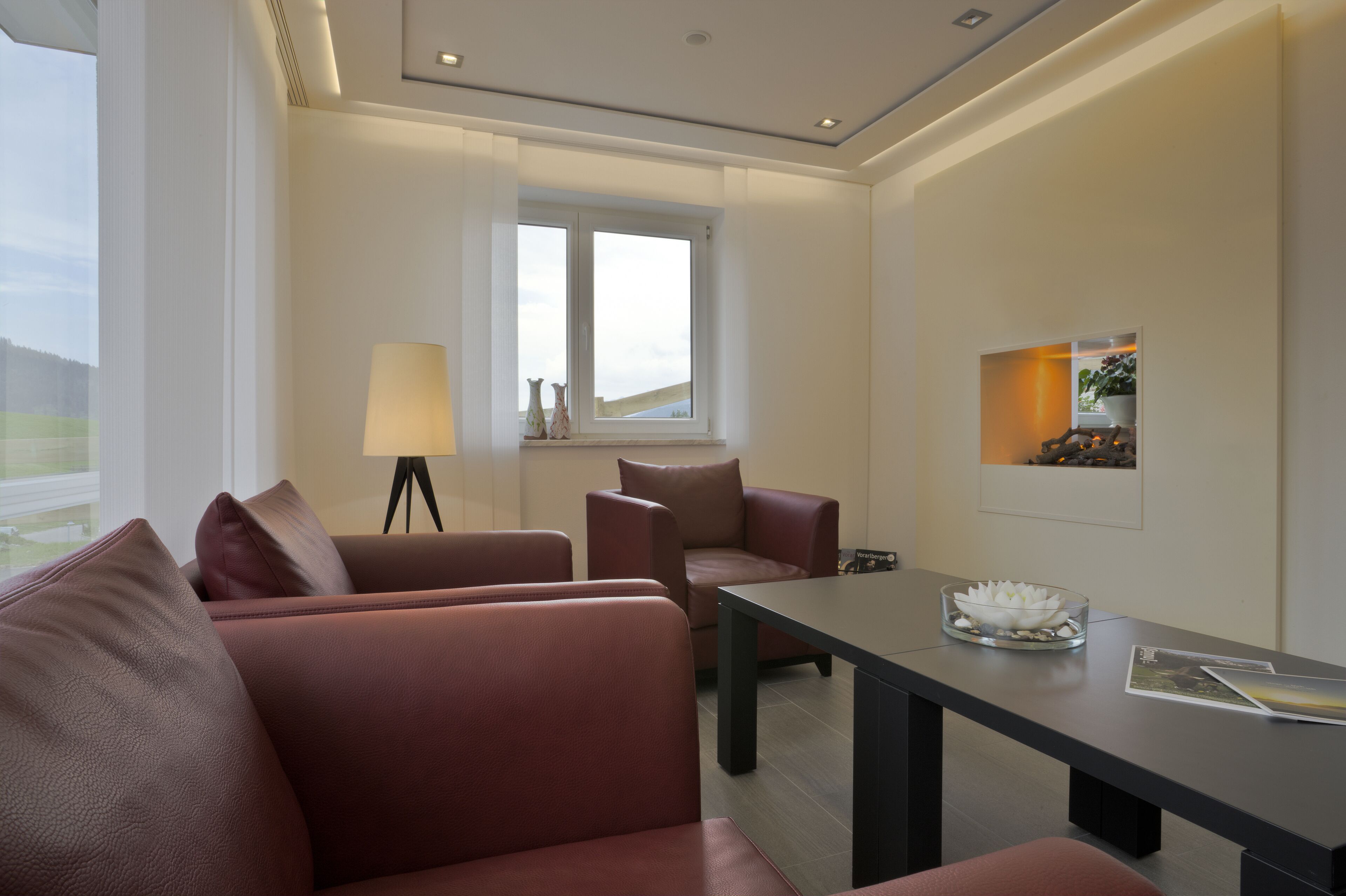 A modern living room with a sofa, a table, and a lamp.