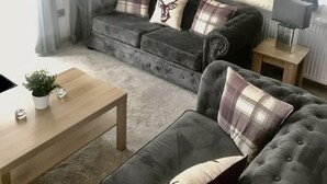 A living room with a sofa set, a coffee table, a lamp, and curtains. - Sherwood Lodge - South Lakeland Leisure Village (Carnforth)
