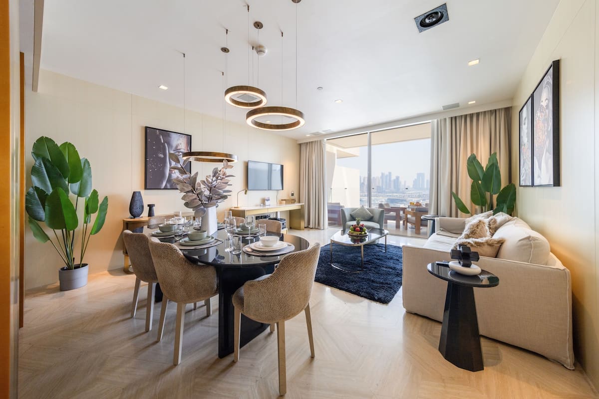 Una sala de estar moderna con comedor, plantas en macetas grandes y vistas a la ciudad.