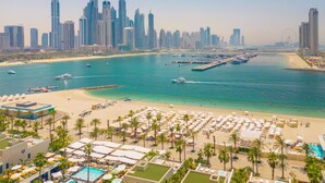 A coastal cityscape with a marina, beach, and high-rise buildings. - EDEN'S Homes & Villas - FIVE Residences (Dubai)