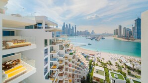 A high-rise hotel with multiple balconies overlooking a beach and city skyline. - EDEN'S Homes & Villas - FIVE Residences (Dubai)