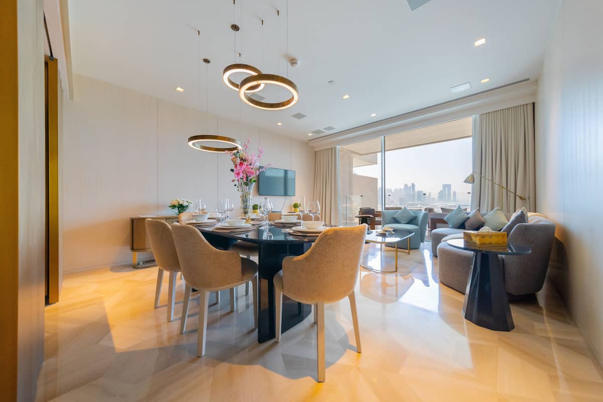 Una sala de estar moderna con comedor, ventanas amplias y vista a la ciudad.