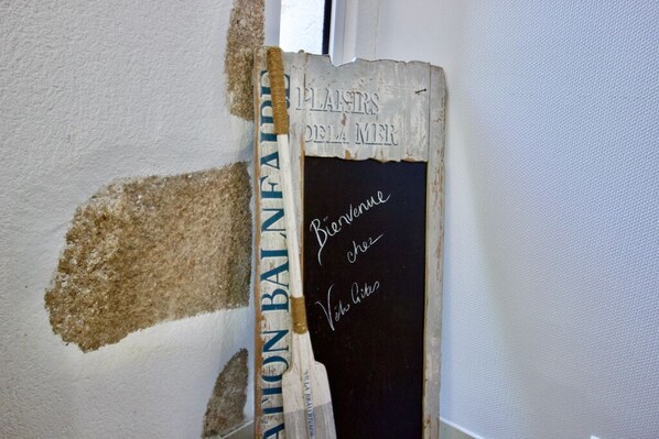 A wall with a rough, unfinished patch and a chalkboard with handwritten text. - VéloGîtes, Le Gîte de la Nature, the perfect place for a family vacation? (Availles-Limouzine)