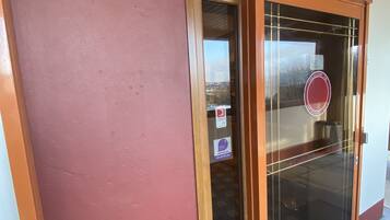 A reception area with a wooden sign above the door and a glass door with a circular logo.