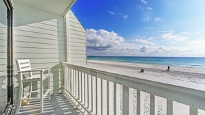 A balcony with a view of a beach and ocean.