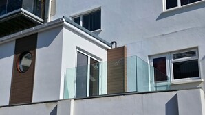 A building with a balcony, a window with a wooden shutter, and a round window. - Great dog friendly 2 bed apartment close to village and beach. (Woolacombe)