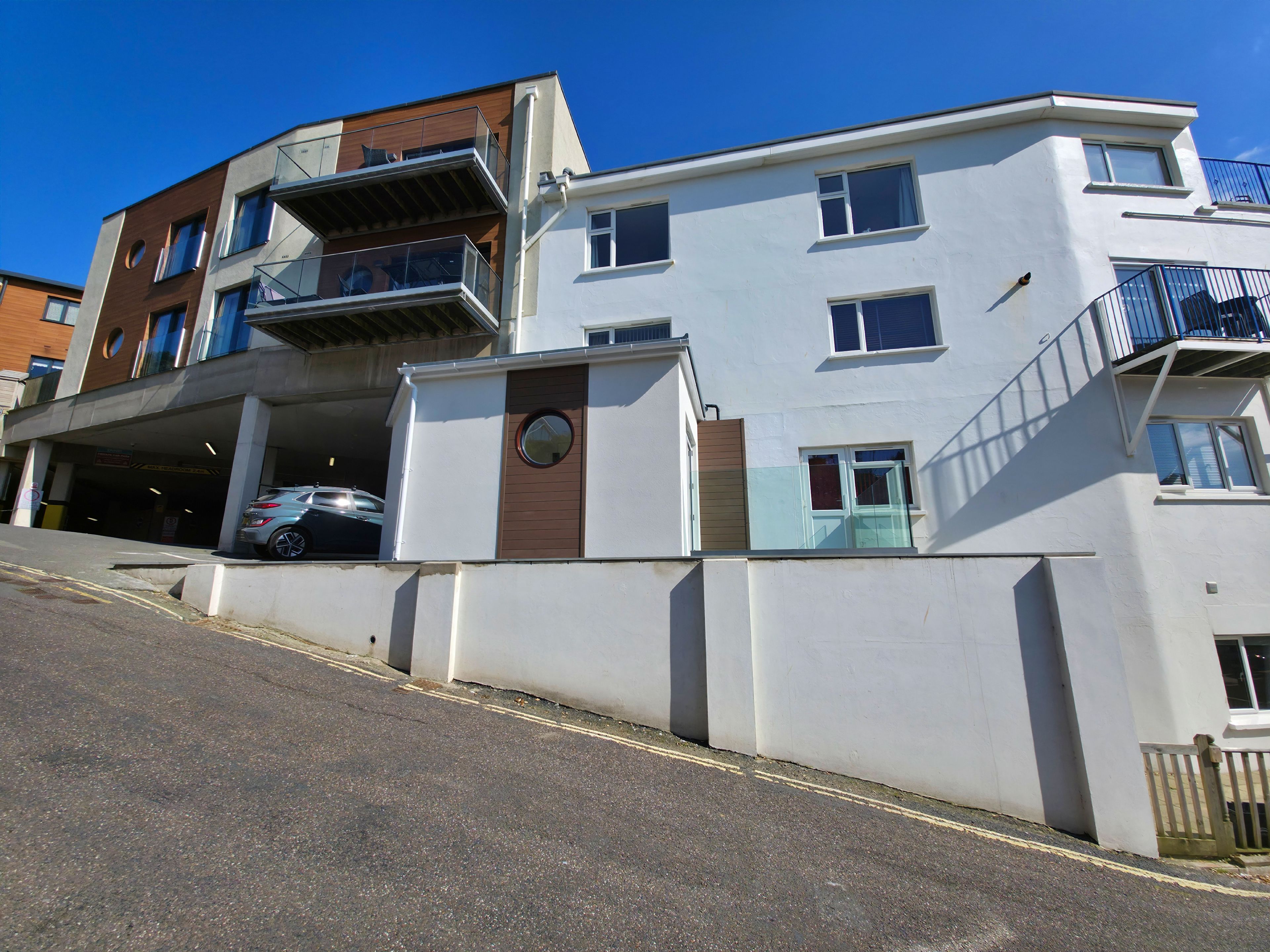 A multi-story residential building with a garage, a staircase, and a balcony.