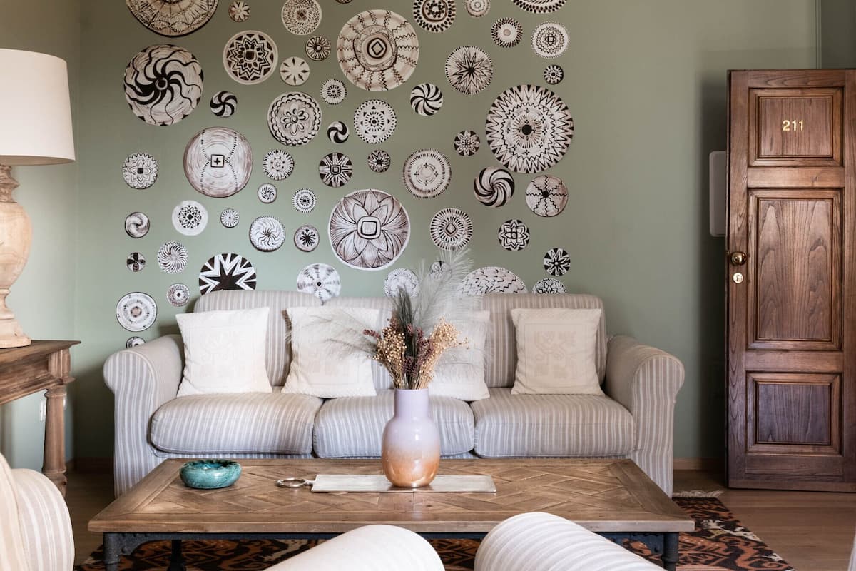 A living room with a sofa, coffee table, and decorative plates on the wall.