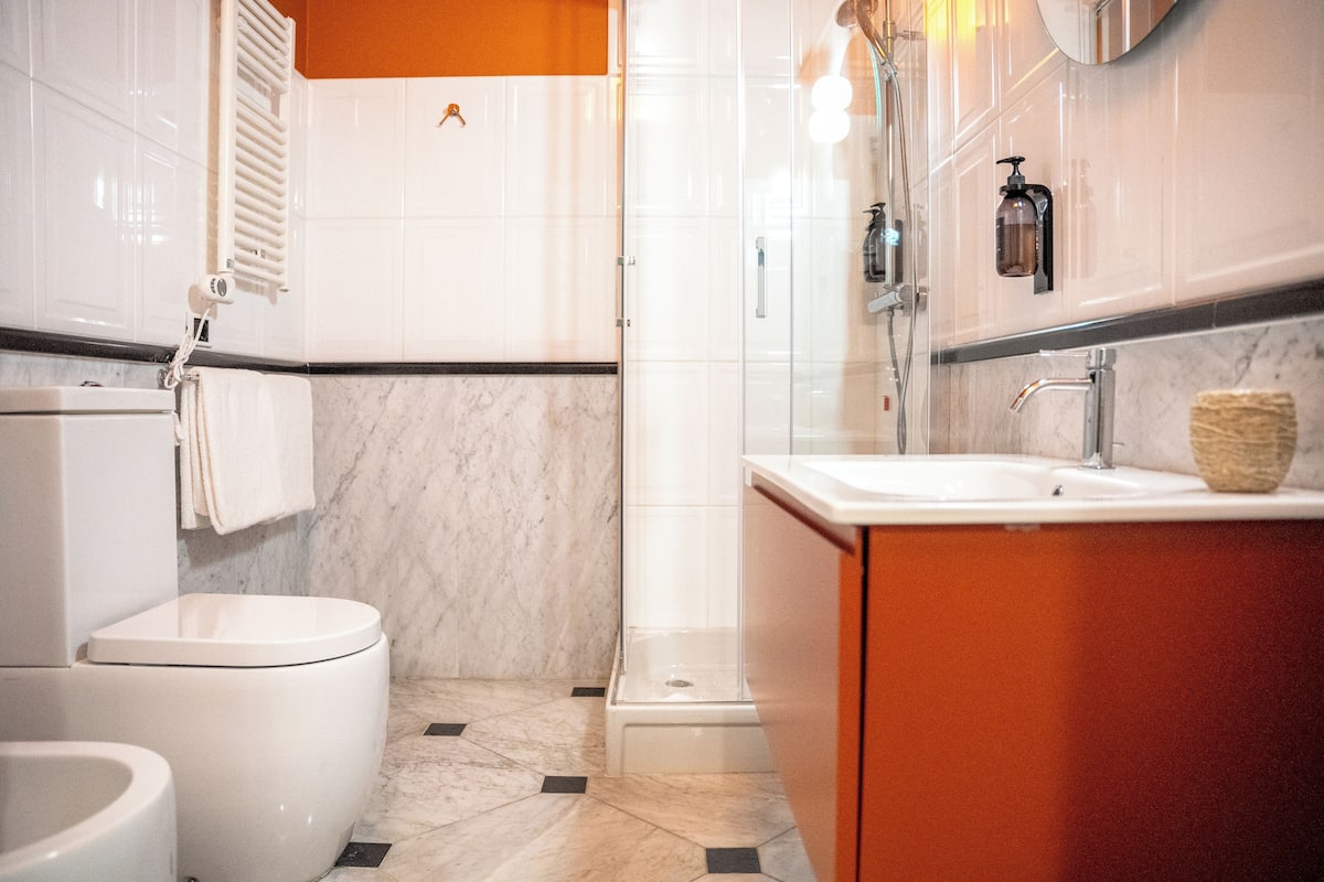 A modern bathroom with a toilet, bidet, and shower.