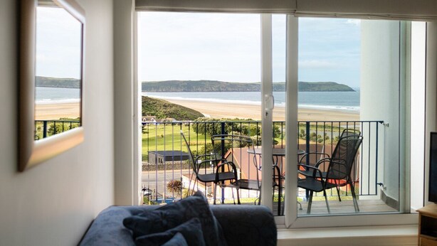 A balcony with a view of the beach and hills. - Cosy 2 bed apartment close to village with 3 balconies and seaviews! (Woolacombe)